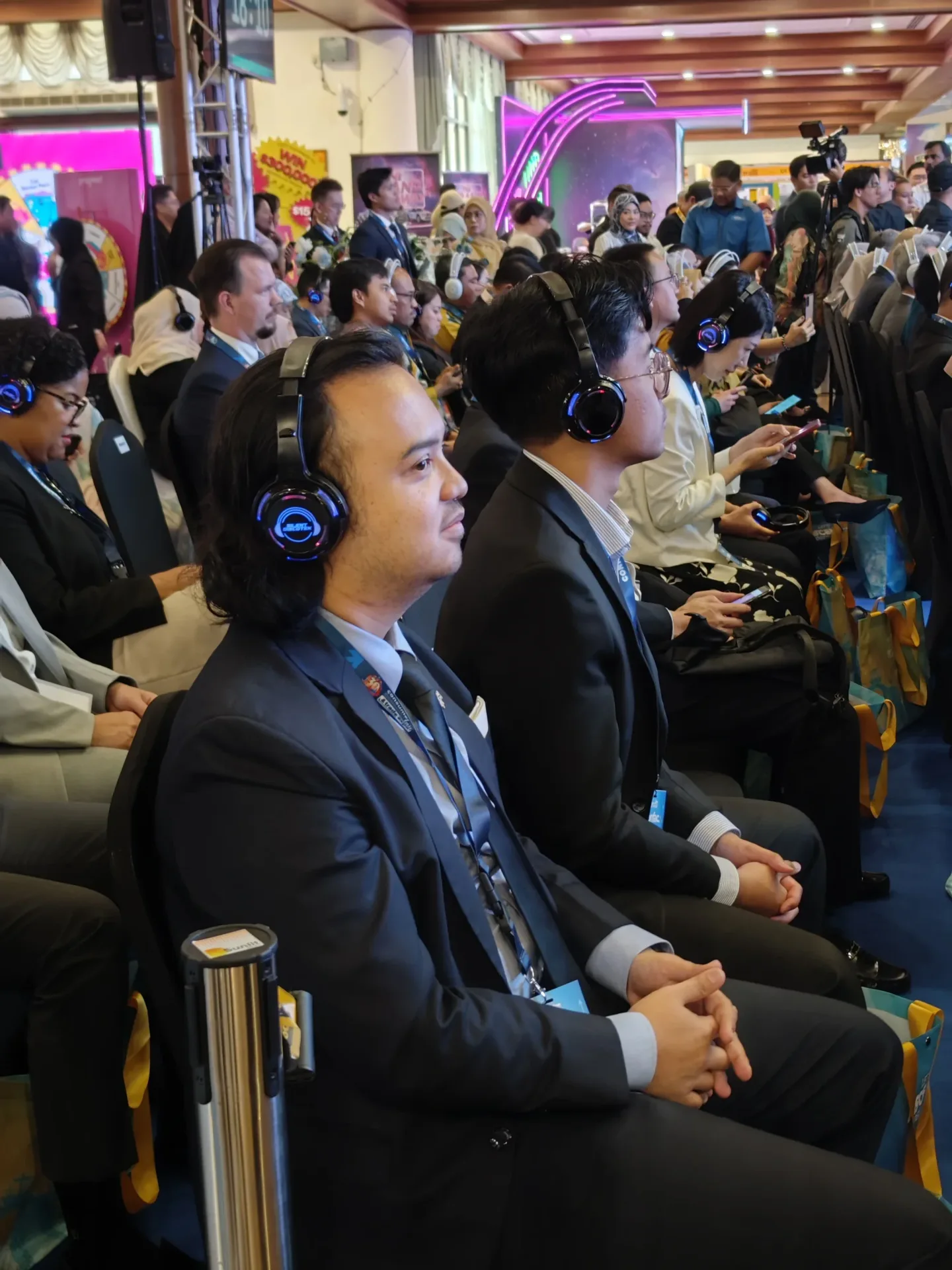 A conference attendee in Malaysia listening to a presentation through wireless headphones