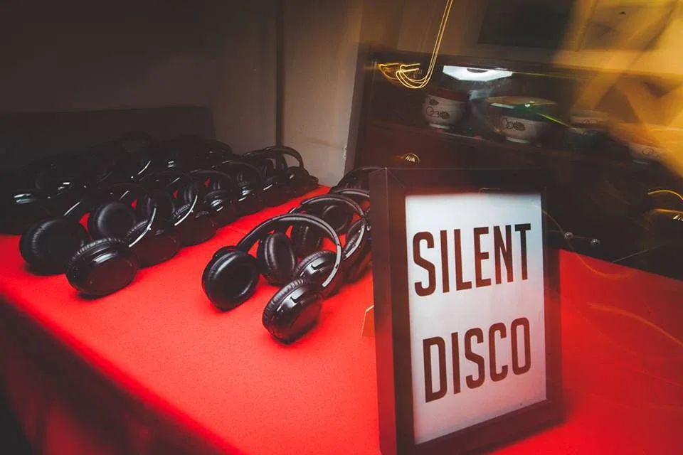 Wireless headphones arranged beside the Silent Disco sign