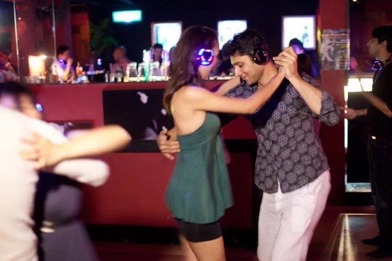 Guests partner dancing with wireless headphones