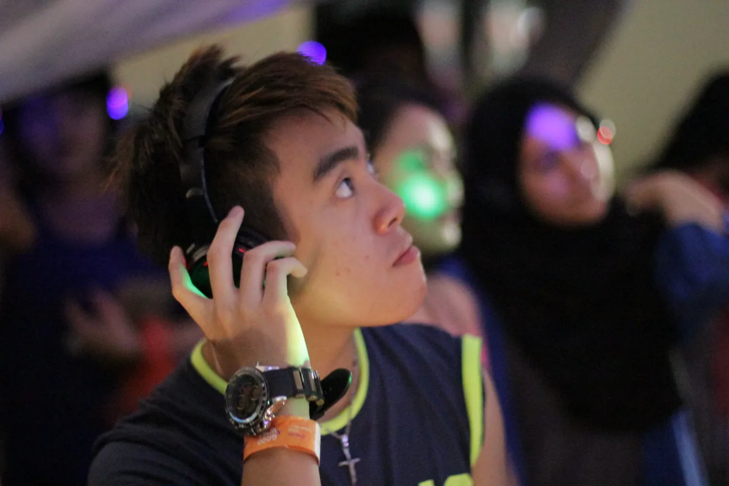 A young festival guest listening through wireless headphones
