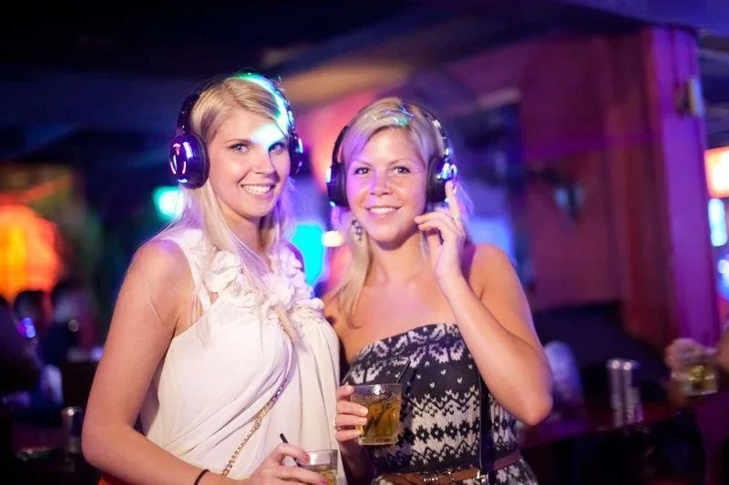 Two guests smiling with headphones at the Preview Party