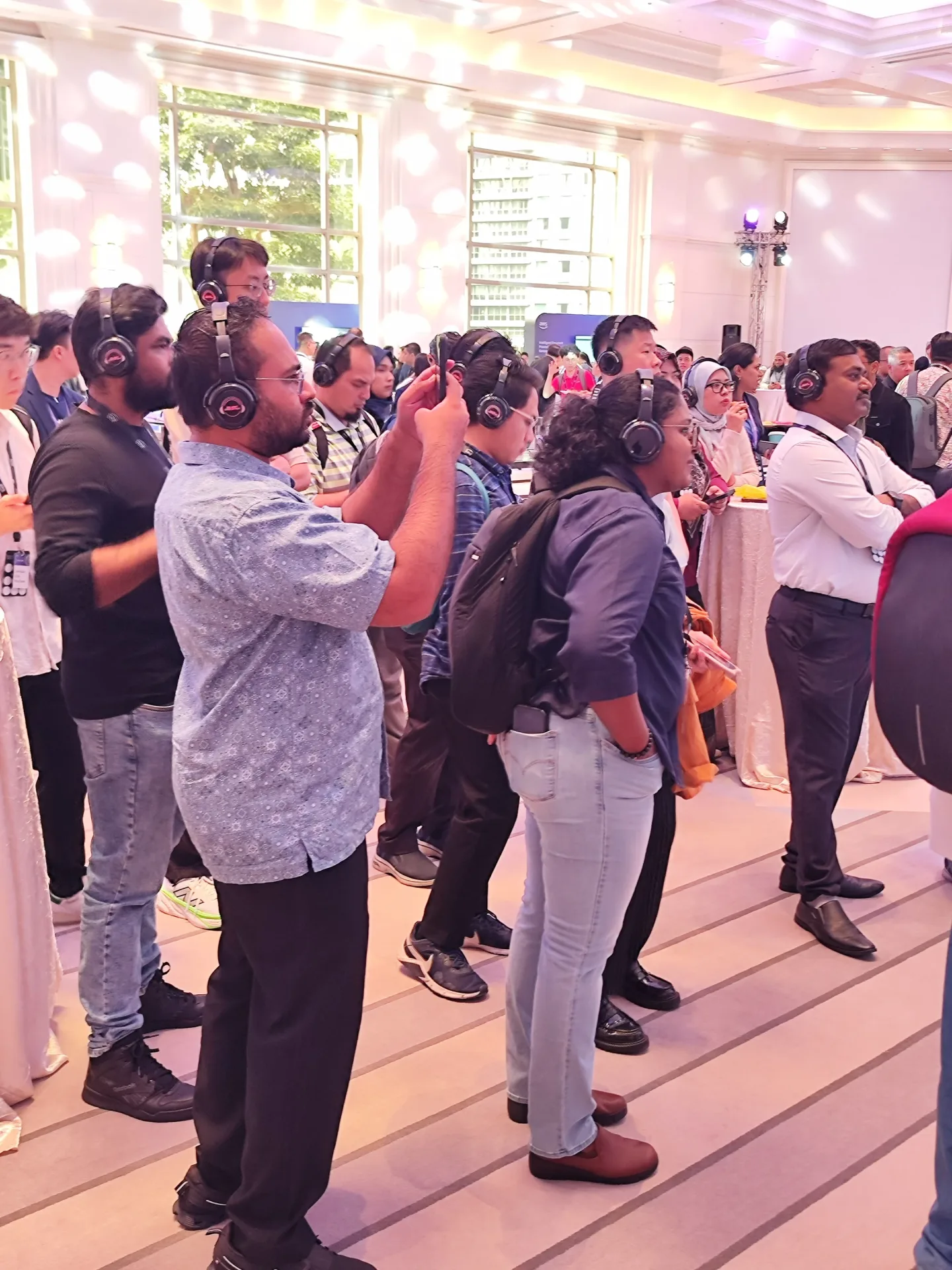 A standing audience taking part in a guided headphone experience