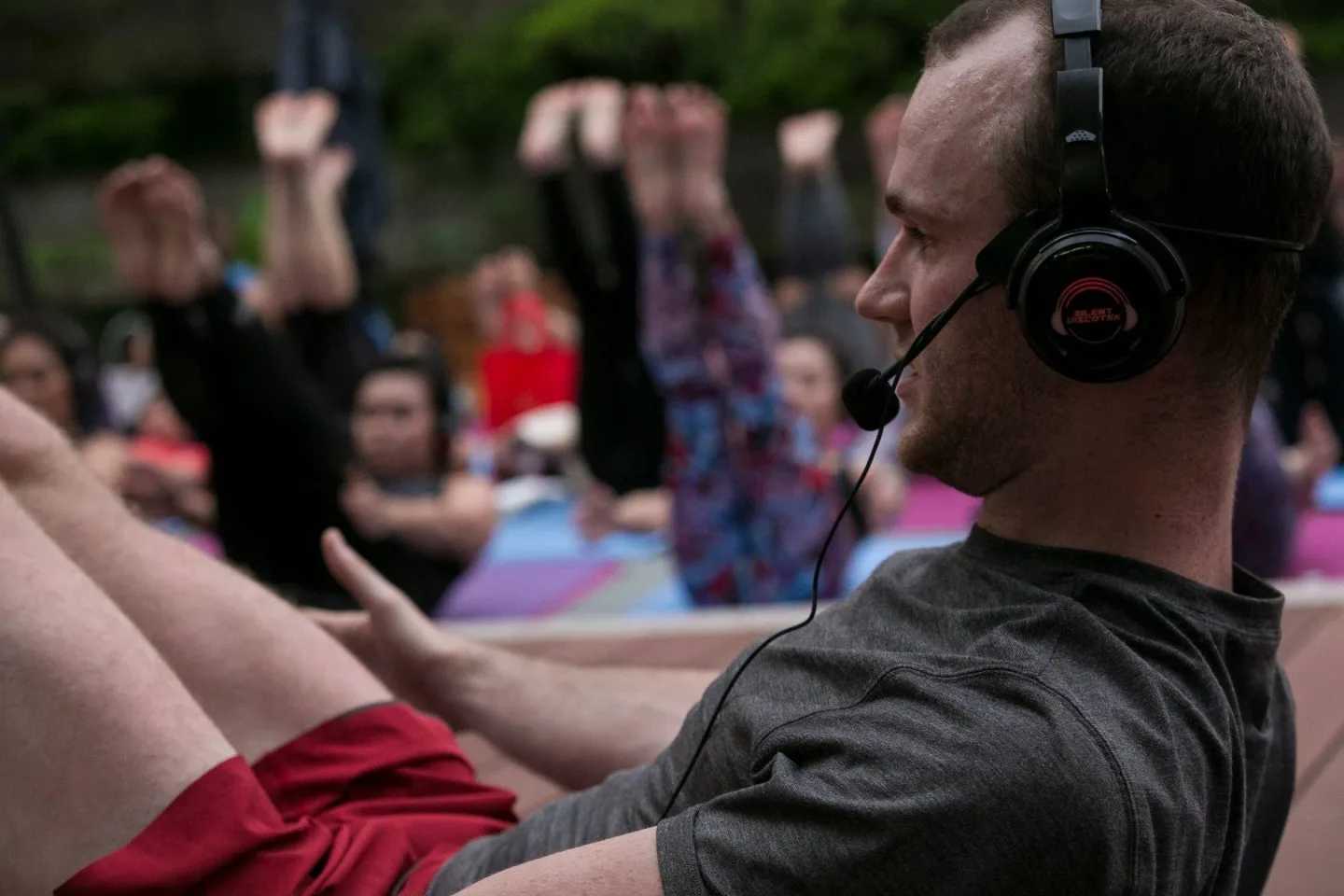 Participants practising a forward fold in the outdoor class