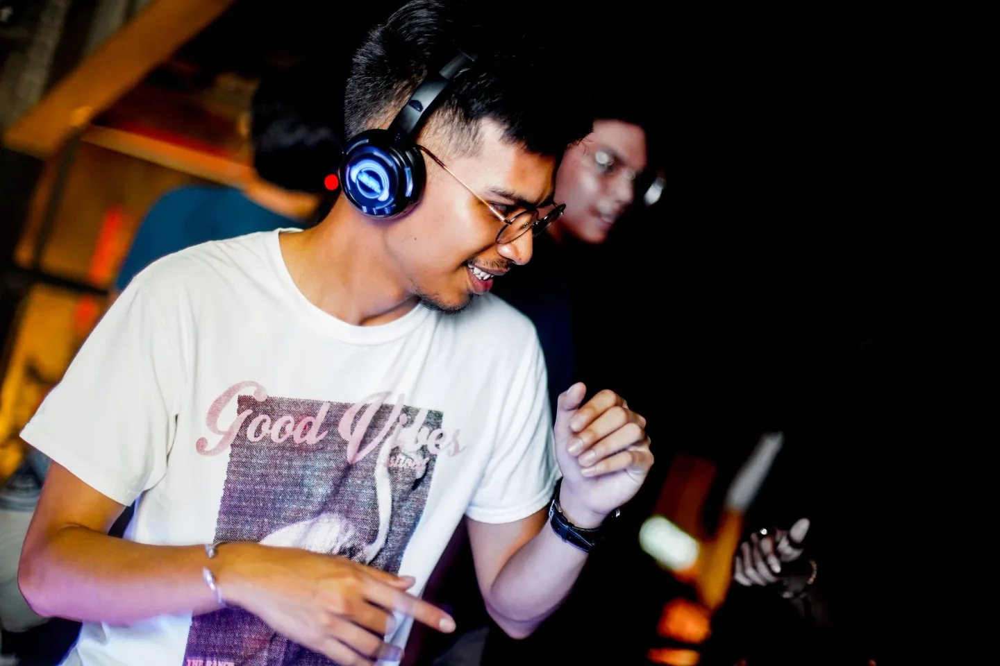 A guest smiling while dancing in wireless headphones at RIUH