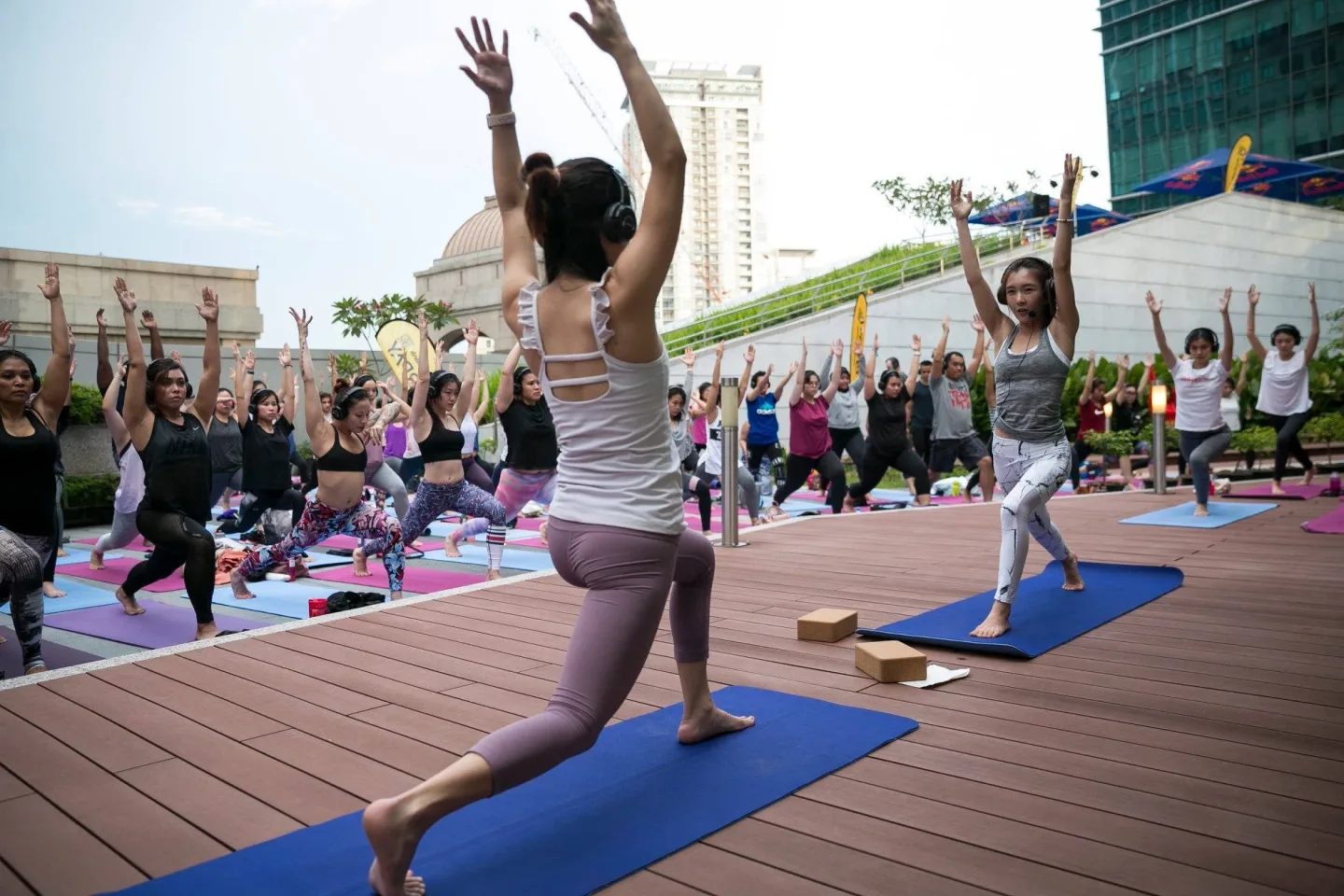 The instructor leading the outdoor silent yoga class