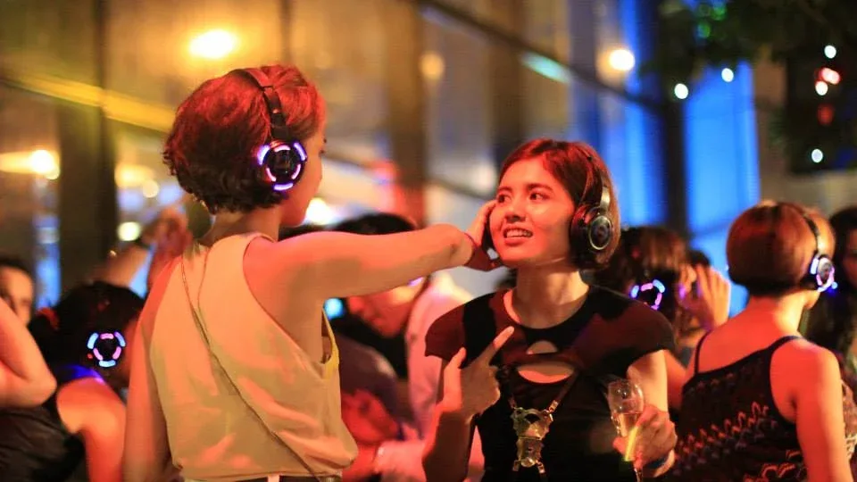 Friends smiling and dancing in wireless headphones