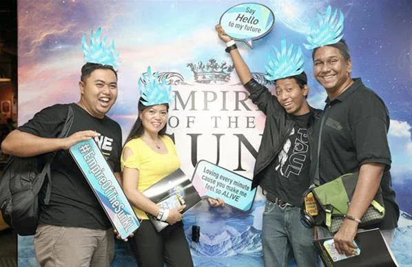 Guests posing beside the Empire of the Sun album display